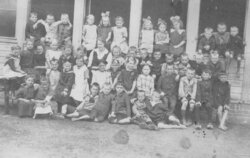 Schulklasse 1925 vor einer Holzbaracke.